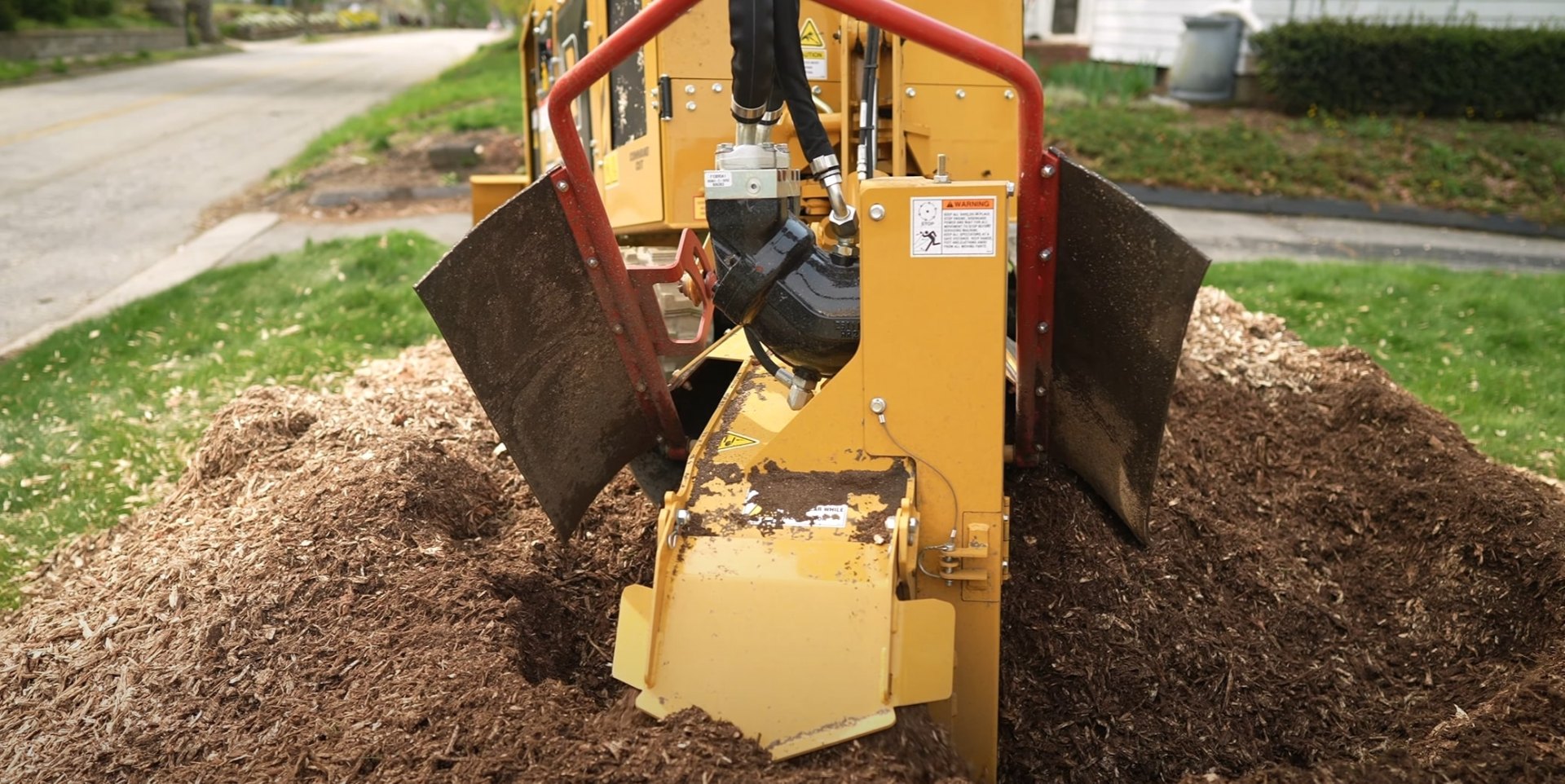 Specialized stump grinder machine working in residential yard Specialized stump grinder machine working in residential yard